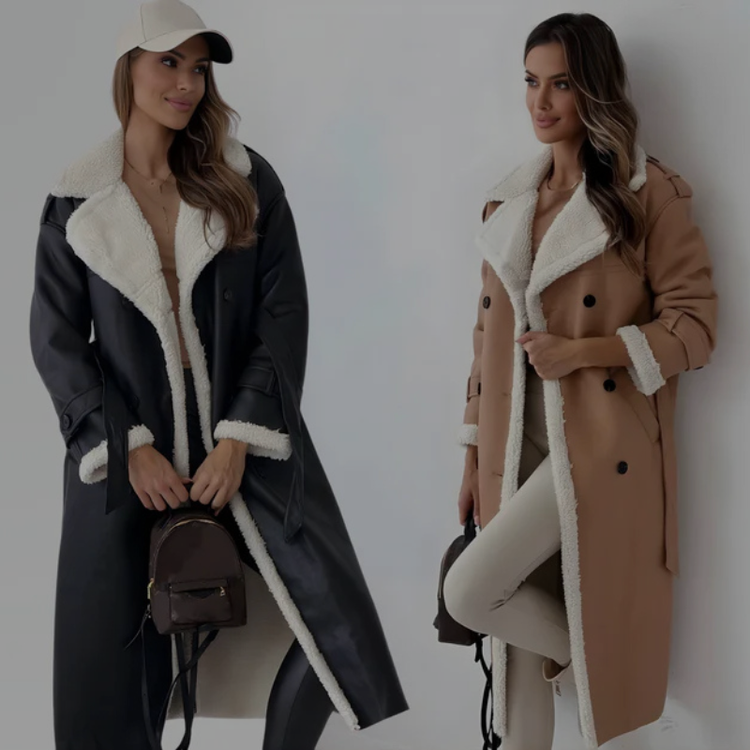 Two women posing in similar long, double-breasted coats with white shearling trim; one coat is black, the other is tan. Both women wear light pants and have loose, wavy hair.